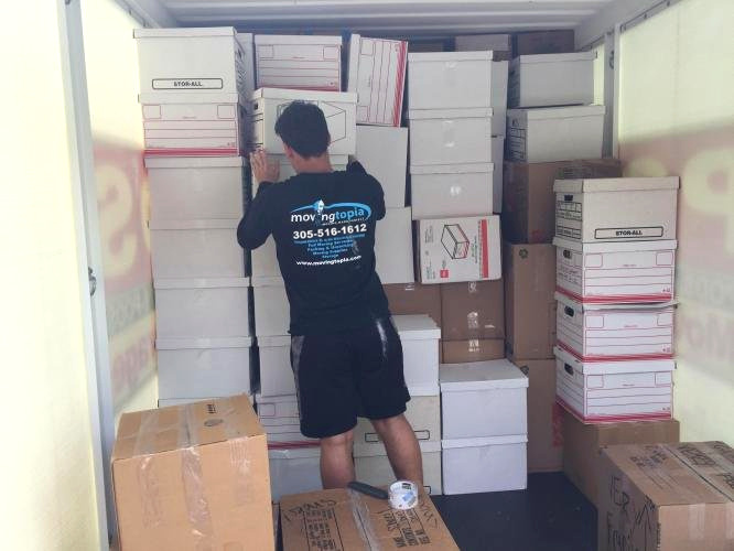 Movingtopia staff organizing packed boxes in a truck