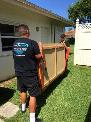 Movingtopia movers carefully carrying furniture together